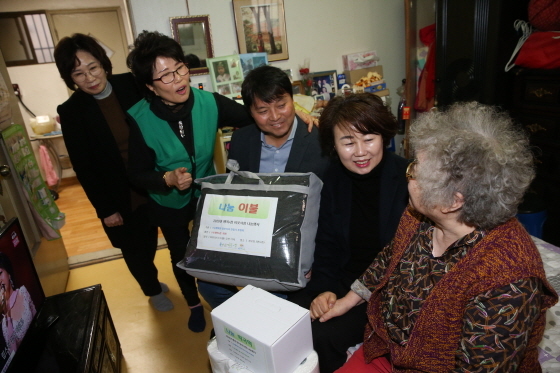 NSP통신-13일 오후 수원노인봉사회 관계자 및 수원시의회 의원들이 노인가정을 방문해 성품을 전달하고 있다. (수원시의회)