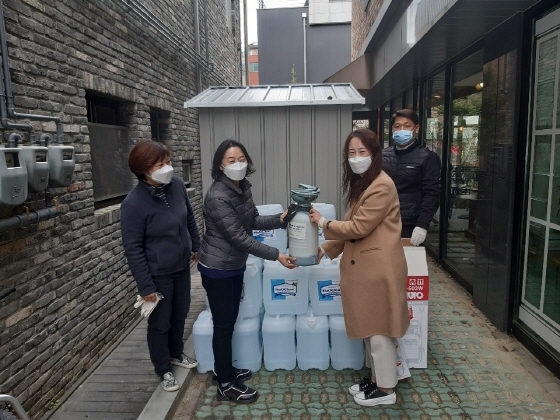 NSP통신-용인시 수지구청 직원이 광교 숲속마을 상인회에 휴대용 소독기와 약품을 무료 대여해 주며 관계자들과 기념촬영을 하고 있다. (용인시)