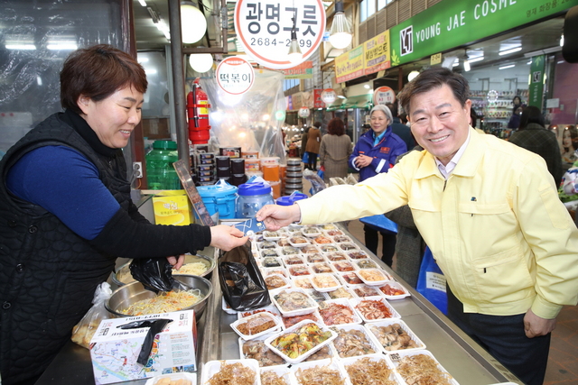 NSP통신-박승원 광명시장이 코로나19로 침체된 지역경제 활성화를 위해 새마을시장에서 물건을 구입하고 상인들을 격려하고 있다. (광명시)