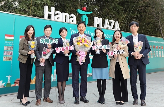 NSP통신-김정태 회장(왼쪽부터 4번째)이 코로나19로 지친 직원들에게 봄 기운 가득한 꽃을 선물하고 기념촬영을 하고 있다.