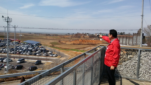 NSP통신-석호현 후보가 군공항 이전 후보예정지로 거론되는 화홍지구를 가리키고 있다. (석호현후보사무실)