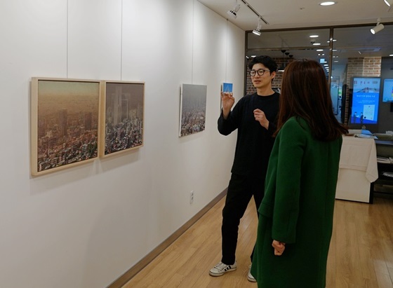 NSP통신-박준형 작가가 유디갤러리를 찾은 관람객에게 작품에 대해 설명하고 있는 모습 (유디치과)