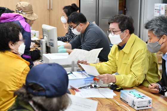 NSP통신-20일 염태영 수원시장(오른쪽 두번째)이 권선1동행정복지센터에서 재난기본소득을 신청하는 시민에게 방법을 안내하고 있다. (수원시)