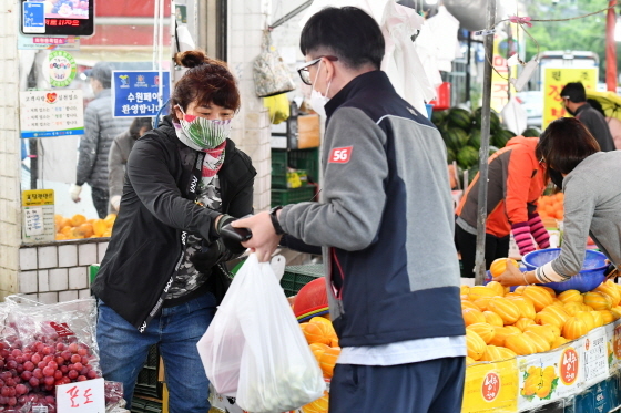 NSP통신-정자시장에서 과일과게를 운영하는 상인이 마스크를 끼고 일하고 있다. (수원시)