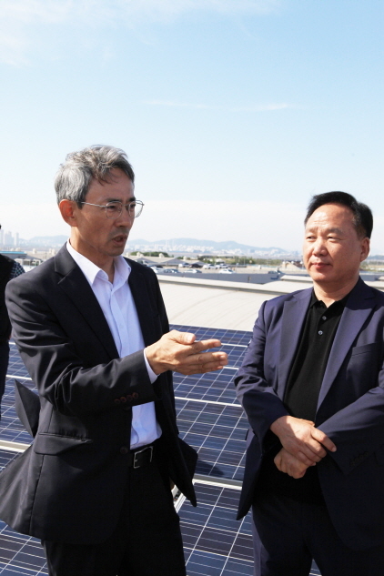 NSP통신-태양광발전시설이 설치된 동원산업 시화물류센터 지붕에서 양근서 안산도시공사 사장(왼쪽)과 윤석규 아이솔라에너지 대표가 태양광발전사업과 관련한 의견을 나누고 있다. (안산도시공사)