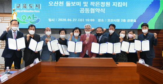 NSP통신-27일 곽상욱 오산시장(왼쪽 여섯번째)과 관계자들이 오산천 돌보미 및 작은정원 지킴이 공동 협약식 후 기념촬영을 하고 있다. (오산시)