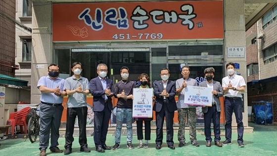 NSP통신-안양창조산업진흥원 임직원들과 안양호계종합시장 상인회 관계자들이 15일 덕분에 챌린지 캠페인에 참여하고 있다. (안양창조산업진흥원)