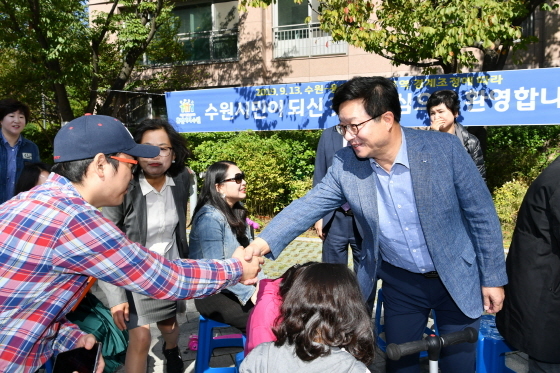 NSP통신-수원시·용인시간 경계조정으로 수원시로 편입된 청명센트레빌 주민들이 마을잔치를 열고 염태영 수원시장(오른쪽)을 초청해 인사하고 있다. (수원시)