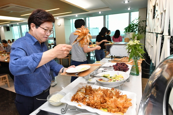 NSP통신-2019년 6월 무안 양파농가돕기를 위해 수원시청이 양파를 대량 구매해 직원들의 조식으로 요리해 제공한 가운데 염태영 수원시장이 음식을 담고 있다. (수원시)