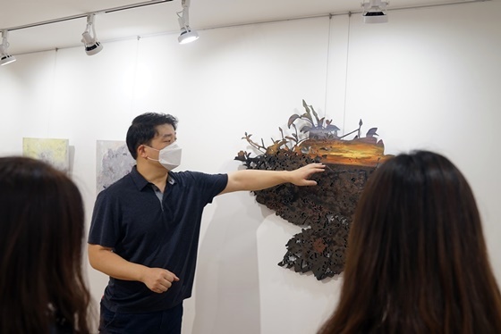 NSP통신-김민수 작가가 유디갤러리를 찾은 관객들에게 작품을 설명하는 모습 (유디치과)