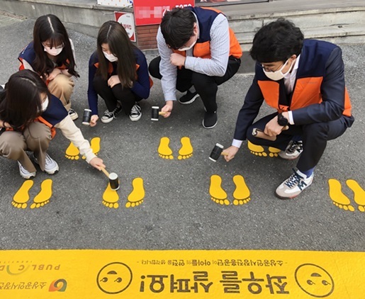 NSP통신-소상공인시장진흥공단 직원들이 어린이보호구역 횡단보도 앞에서 노란 발자국을 설치하고 있다. (소진공)
