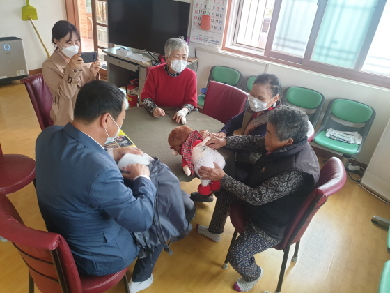 -노인들이 인공지능 돌봄로봇을 살펴보고 있다. (화성시)