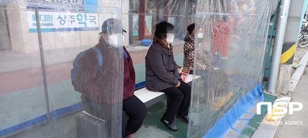 NSP통신-시민들이 버스승강장에서 탄소발열에어벤치에 앉아 버스를 기다리고 있다. (상주시)