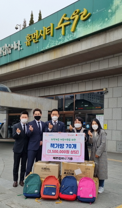 NSP통신-12일 임유정 수원시 복지협력과장(오른쪽 두번째)과 김현수 헤븐컴퍼니 대표(가운데) 및 관계자들이 책가방 기탁식 후 기념촬영을 하고 있다. (수원시)