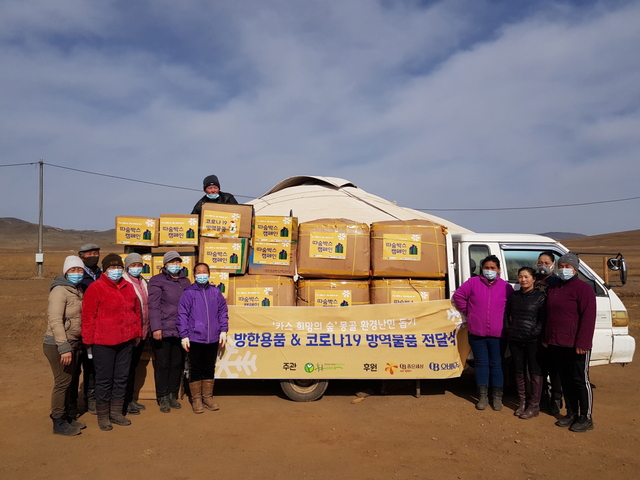 NSP통신-에르덴 솜 카스 희망의 숲 하늘마을 주민들이 푸른아시아의 현지 대리인과 따숨박스 전달식에 참석해 기념 사진을 찍고 있다.