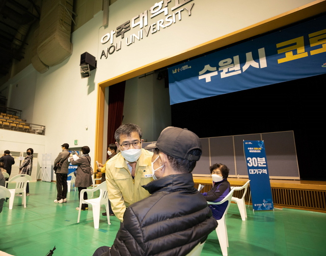 NSP통신-코로나19 수원1호 예방접종센터인 아주대학교 실내체육관 현장을 방문한 이용철 경기도행정1부지사가가 접종 대기구역에서 한 어르신을 만나 백신 접종에 앞서 살피고 있다. (경기도)