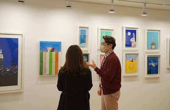 NSP통신-송형노 작가(오른쪽)가 유디갤러리를 방문한 관객에게 작품을 설명하는 모습 (유디치과)