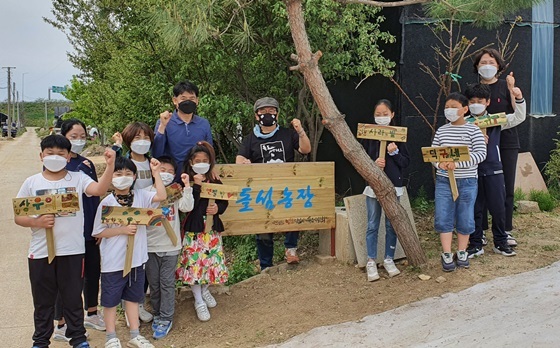 NSP통신-농장 앞에서 자신들이 만든 텃밭 명패를 들고 기념촬영하는 어린이와 지도교사 (검정옷,정광태교수) (독도사랑회)