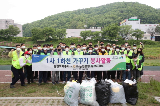 NSP통신-4일 백군기 용인시장이 처인구 마평동 종합운동장 인근 경안천을 찾아 자원봉사 중인 용인도시공사, NH농협 관계자들을 격려하고 단체기념촬영을 하고 있다. (용인시)