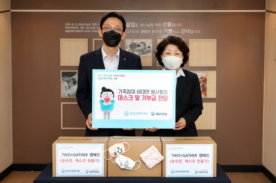 NSP통신-마스크와 기부금 전달식을 하고 있는 강기남 대우건설 관리지원실장(왼쪽), 김진숙 동방사회복지회 회장(오른쪽)이 기념사진 찍고 있다. (대우건설)