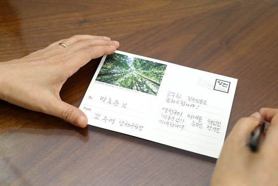 NSP통신-김수영 양천구청장이 6개월간의 시보기간을 마친 새내기 공무원들에게 축하 엽서를 쓰고 있다. (양천구)