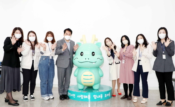 NSP통신-시 청사 1층 포토존에 설치된 시 소셜캐릭터 조아용 조형물 앞에서 백군기 용인시장(왼쪽 네번째)과 공보관실 직원들이 기념사진을 찍고 있다. (용인시)