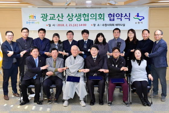 NSP통신-광교산 상생협의회가 7개월간의 숙의 끝에 합의를 이뤄낸 뒤 2018년 2월 협약식에서 손을 맞잡고 기념촬영을 하고 있다. (수원시)