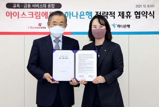 NSP통신-김소정 하나은행 디지털리테일그룹 부행장(오른쪽)과 박기석 아이스크림에듀 대표(왼쪽)가 협약서를 들고 기념촬영을 하고 있다. (하나은행)