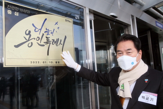 NSP통신-3일 백군기 용인시장이 용인시청사 입구에 용인특례시 현판을 걸고 있다. (용인시)