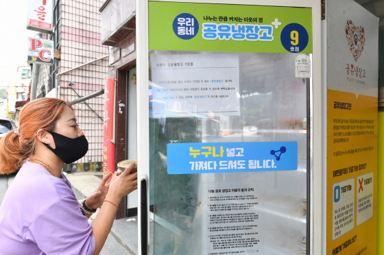 NSP통신-먹거리 나눔을 위해 설치된 공유냉장고를 관리하고 있는 자원봉사자 모습. (수원시)