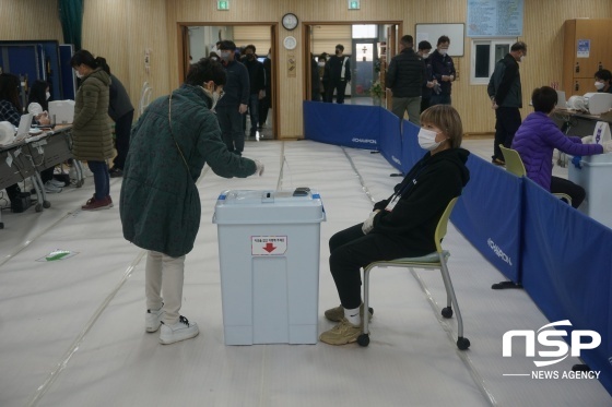NSP통신-사전투표소에서 한 유권자가 선관위 관계자가 지켜보는 가운데 투표용지를 투표함에 넣고 있다. (김병관 기자)
