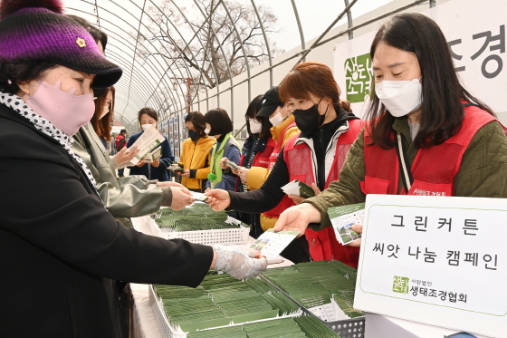 NSP통신-24일 생태조경협회 회원들이 시민들에게 씨앗이 든 봉투를 나눠주는 모습. (수원시)