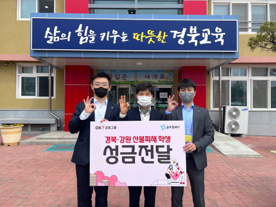 NSP통신-난 21일 경북 울진군에 위치한 부구초등학교에서 OK금융그룹 관계자를 비롯한 도영진 부구초 교장(가운데)이 산불 피해 학생 지원을 위한 성금 전달식에서 기념촬영을 하고 있다. (OK금융그룹)