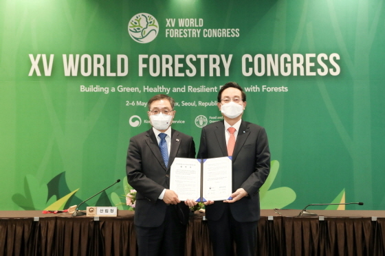 NSP통신-우리금융그룹(회장 손태승)은 지난 2일 서울 코엑스에서 개최된 제15차 세계산림총회(World Forestry Congress)에 손태승 우리금융그룹 회장(오른쪽)과 최병암 산림청장(왼쪽)이 참석한 가운데 탄소중립 활동과 ESG경영 상호협력을 위한 업무협약을 체결했다. (우리금융그룹)