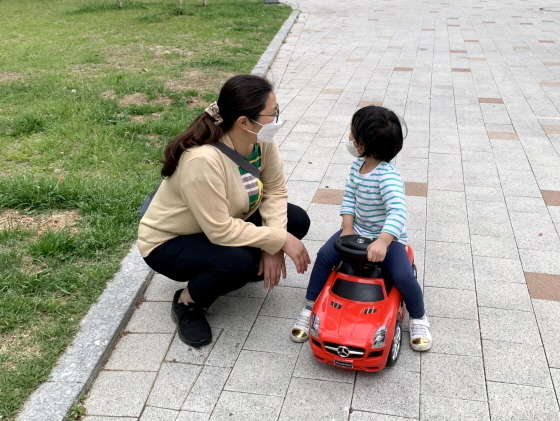 NSP통신-영아전담 돌보미 이지영씨가 서비스 대상 아동과 집앞 놀이터에서 바깥놀이를 즐기고 있다. (용인시)