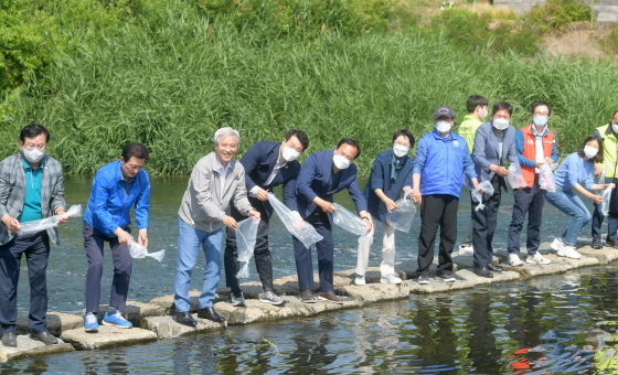 NSP통신-11일 생태교란식물 제거 및 치어방류 행사에서 곽상욱 오산시장(왼쪽 세번째), 장인수 오산시의회 의장(왼쪽 네번째), 이권재 오산시장 당선인(왼쪽 다섯번째) 등 참석자들이 토종붕어 치어를 방류하는 모습. (오산시)