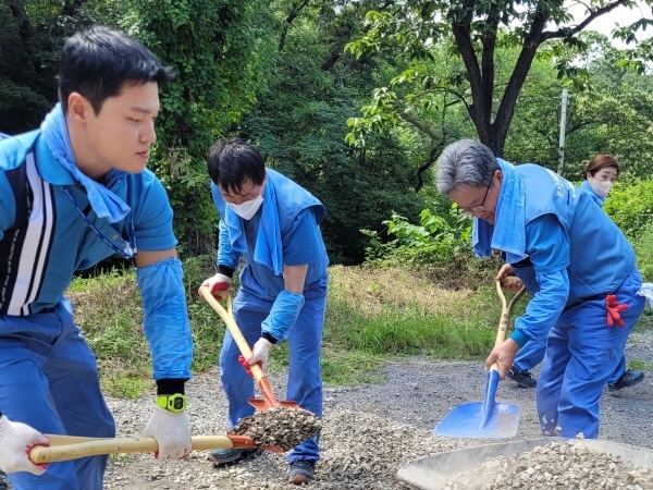 NSP통신-포스코스틸리온 윤양수 사장과 직원들이 운제산 산림욕장 진입 도로를 보수하고 있다.