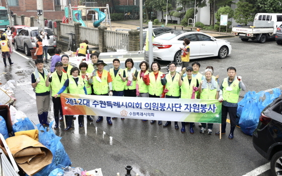 NSP통신-11일 수해복구 지원에 나선 수원시의회 김기정 의장(앞 줄 오른쪽 여덟번째)과 의원들이 기념촬영을 하고 있다. (수원시의회)