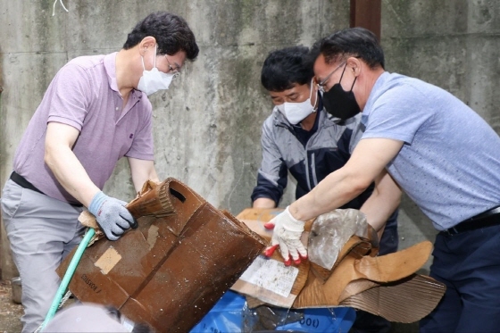 NSP통신-이상일 용인특례시장이 침수된 주택 앞에 쌓인 토사물을 걷어내고 폐기물을 치우는 작업을 하고 있다. (용인특례시)