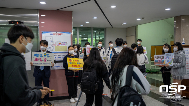 NSP통신-운양고등학교 학생들이 학교 폭력 예방 피켓을 보고 교실로 올라가고 있다. (조이호기자)