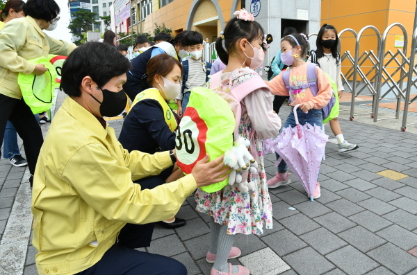 NSP통신-경산시는 2일 개학일 맞아 차량 통행량이 많은 성암초등학교 어린이보호구역에서 학생들의 등교 시간에 맞춰 가방에 스쿨존 가방 안전 커버를 씌우는 캠페인을 했다. (경산시)