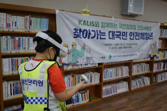 NSP통신-김해시 한 도서관에서 찾아가는 안전체험존 행사에 참여한 청소년이 건설안전 사고를 VR로 체험하고 있다 (국토안전관리원)