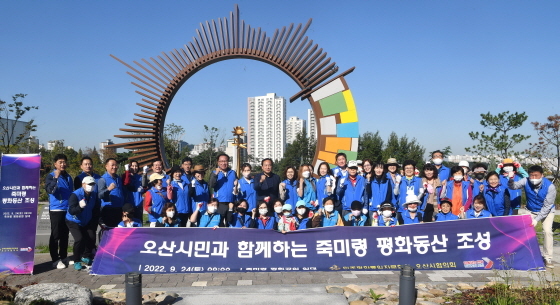 NSP통신-24일 평화공원 조성 행사에서 이권재 오산시장(가운데)와 참석자들이 기념촬영을 하는 모습. (오산시)