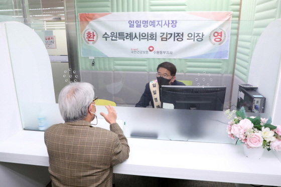 NSP통신-2일 김기정 수원시의회 의장(뒤)이 국민건강보험공단 수원동부지사에서 민원 상담을 하고 있다.