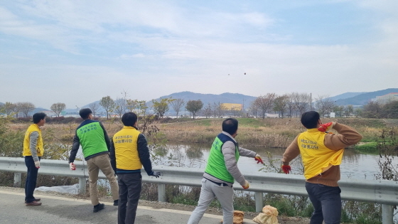 NSP통신-공사 위탁사업팀 관계자들이 관내 하천 수질 정화를 위해 용인시 환경과로부터 지원받은 EM흙공을 청미천 수계 일원에 투척하고 있다. (용인도시공사)