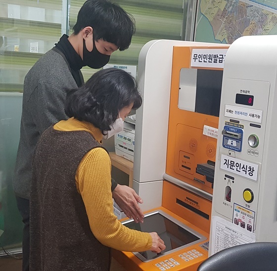 NSP통신-주민센터에서 디지털약자의 무인민원발급을 돕는 모습 (양천구)