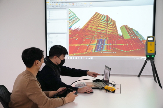 NSP통신-롯데건설 관계자들이 3D스캐너를 활용해 기존 아파트 모델링 데이터를 확인하고 있다 (롯데건설)