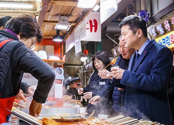 NSP통신-김태우 서울 강서구청장(오른쪽 첫 번째)이 화곡동에 위치한 까치산시장을 찾아 어묵을 시식하고 있다. (강서구)