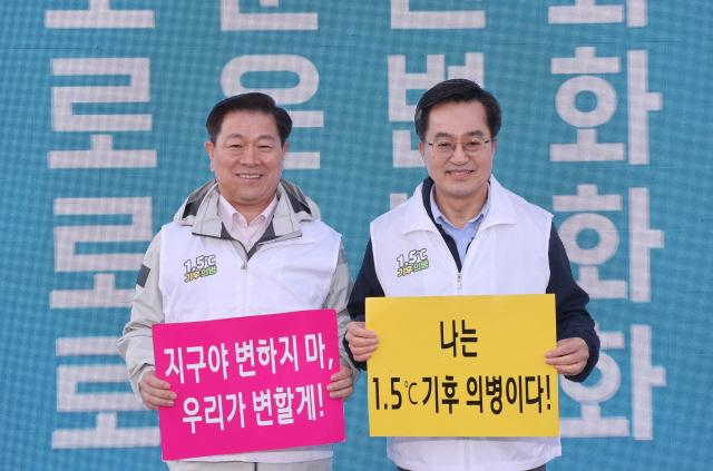 NSP통신-광명시와 경기도가 28일 일직동 새빛공원에서 기후위기 대응 주제로 진행한 맞손토크에서 박승원 시장(왼쪽)과 김동연 경기도지사가 기후위기 공등 대응 퍼포먼스 기념촬영을 하고 있다. (사진 = 광명시)