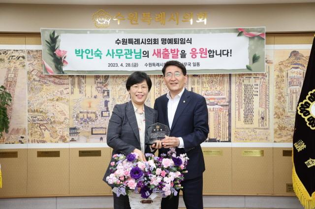 NSP통신-28일 김기정 수원시의회 의장(오른쪽)이 명예퇴직하는 박인숙 사무관과 사진촬영을 하고 있다. (사진 = 수원시의회)